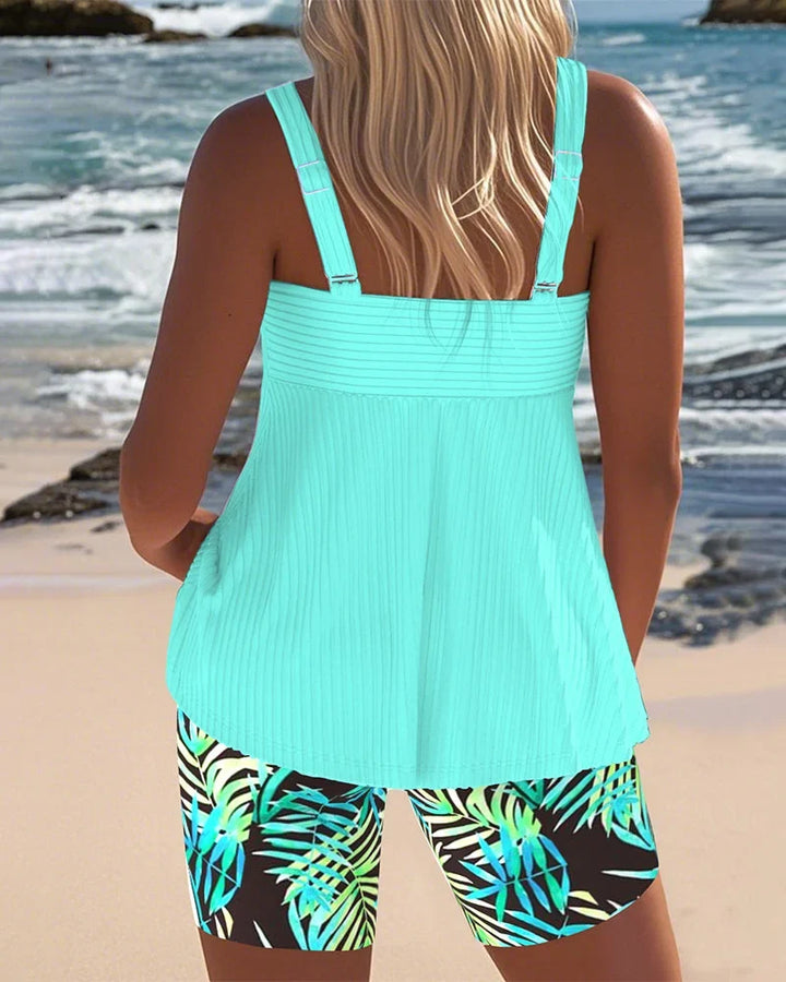 Tummy-control ribbed tankini for women, featuring a chic twist-front top & vibrant tropical print shorts. Plus size friendly.