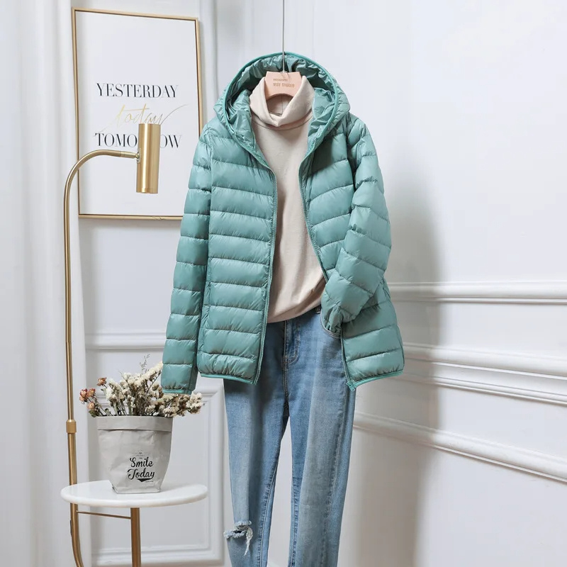 "Women's ultralight foldable puffer jacket with hood, chic design, lightweight, perfect for travel and cold weather."