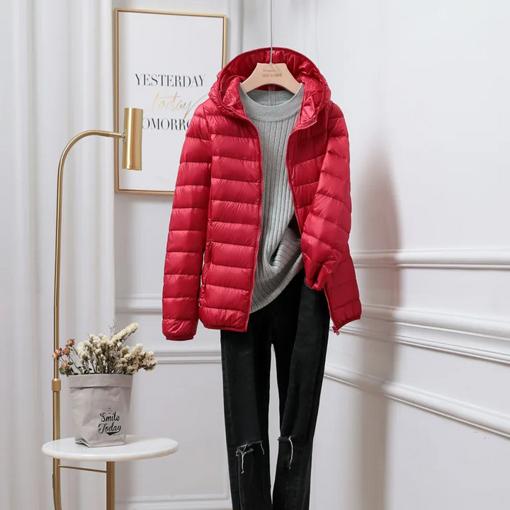 "Women's ultralight foldable puffer jacket with hood, chic design, lightweight, perfect for travel and cold weather."
