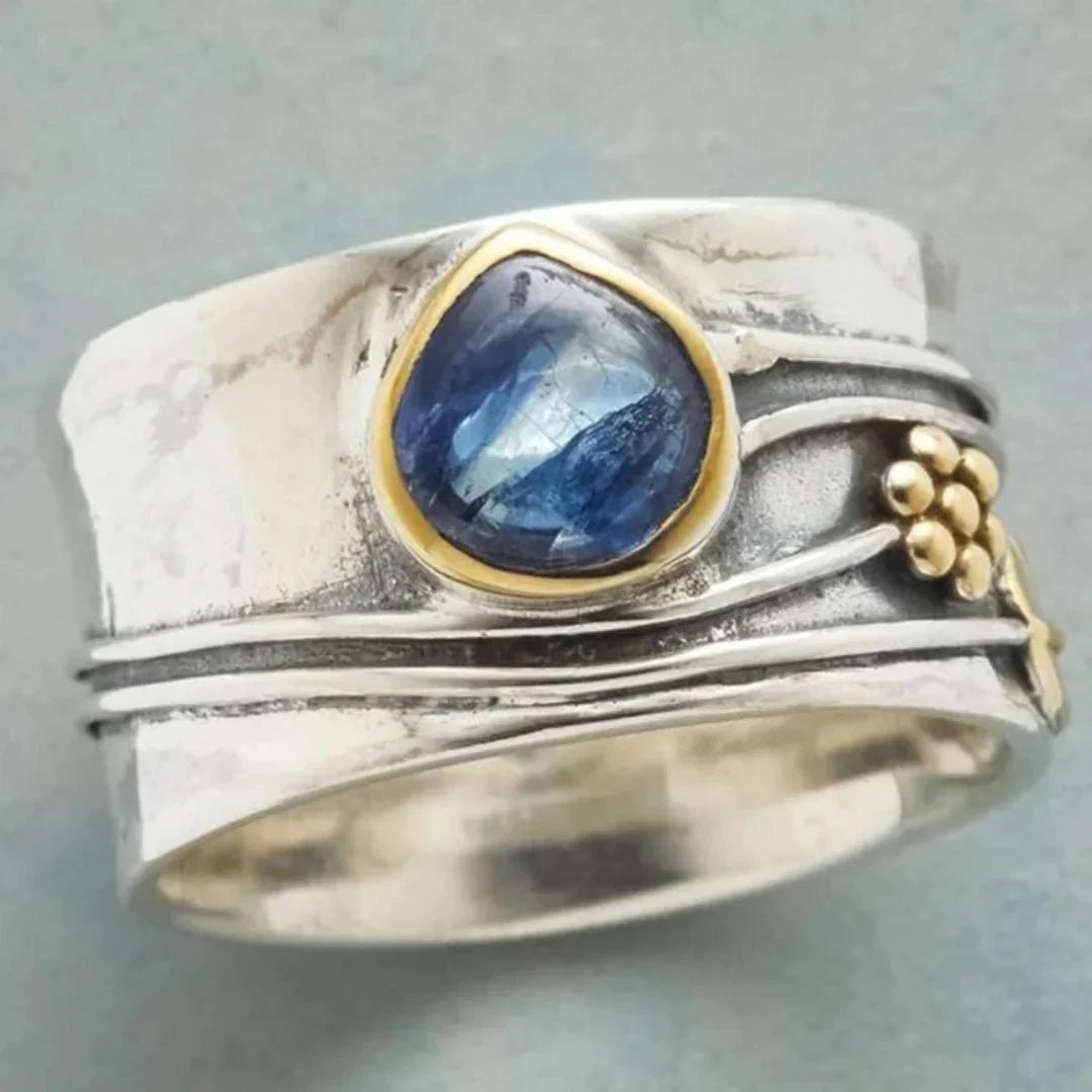 Elegant women's vintage two-tone blue stone ring with intricate gold accents, a timeless statement jewelry piece.