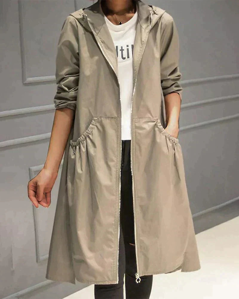 Women's waterproof hooded jacket in knee-length, relaxed fit, shown in lightweight fabric with ruched pockets for stylish cov