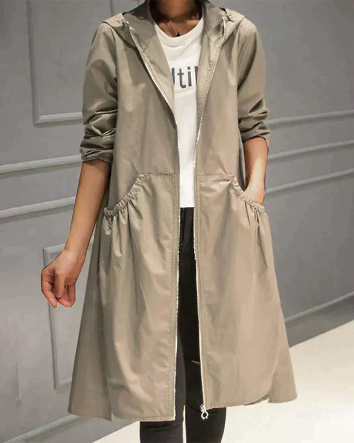 Women's waterproof hooded jacket in knee-length, relaxed fit, shown in lightweight fabric with ruched pockets for stylish cov