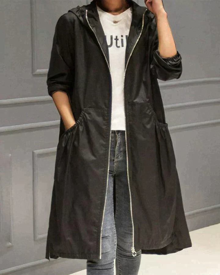 Women's waterproof hooded jacket in knee-length, relaxed fit, shown in lightweight fabric with ruched pockets for stylish cov