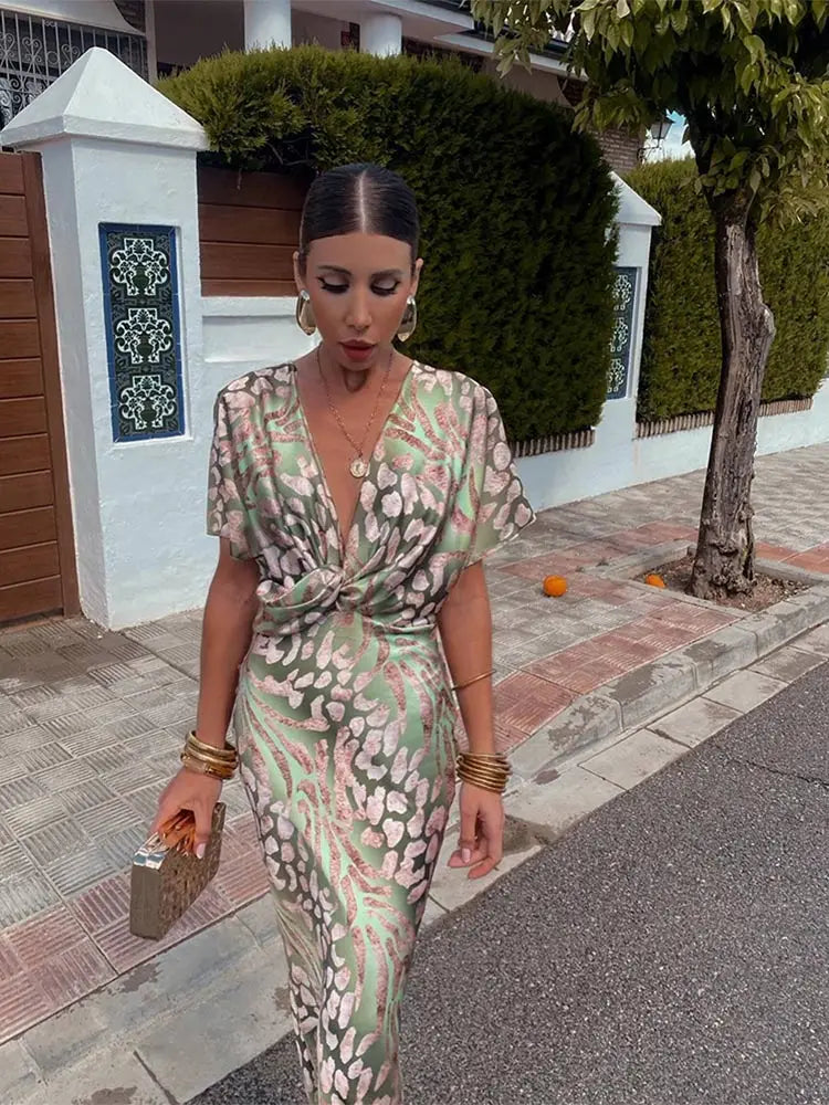 Elegant women's wedding guest midi dress with a unique twist-front, vibrant print, and flattering V-neck.