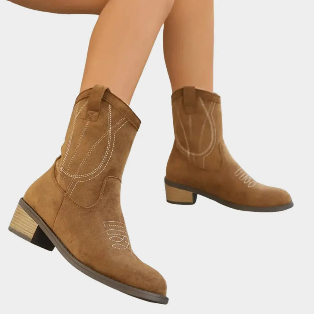 Side view of women's Western-style ankle boots, showcasing unique stitching patterns and a trendy block heel.