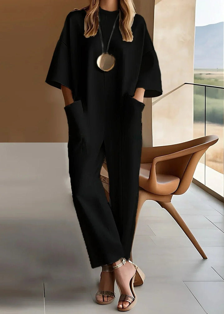 Modern women's wide leg jumpsuit. Features short sleeves, crew neck, & flowy design for versatile wear.