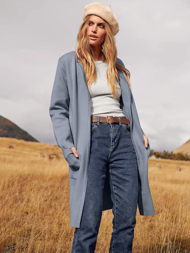 "Women's wool blend knee-length coat with wide lapel and patch pockets, showcasing a relaxed fit and minimalist design."