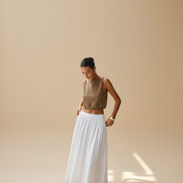 Chic women's white sleeveless crop top, high neck, textured fabric for an elegant summer look.