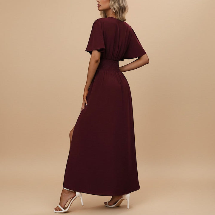 Close-up of the V-neck and delicate flutter sleeves on an elegant women's maxi dress with defined waist.