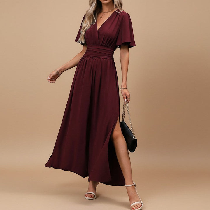 Full-length shot of a long women's V-neck flutter sleeve maxi dress, accentuating the flattering defined waist.