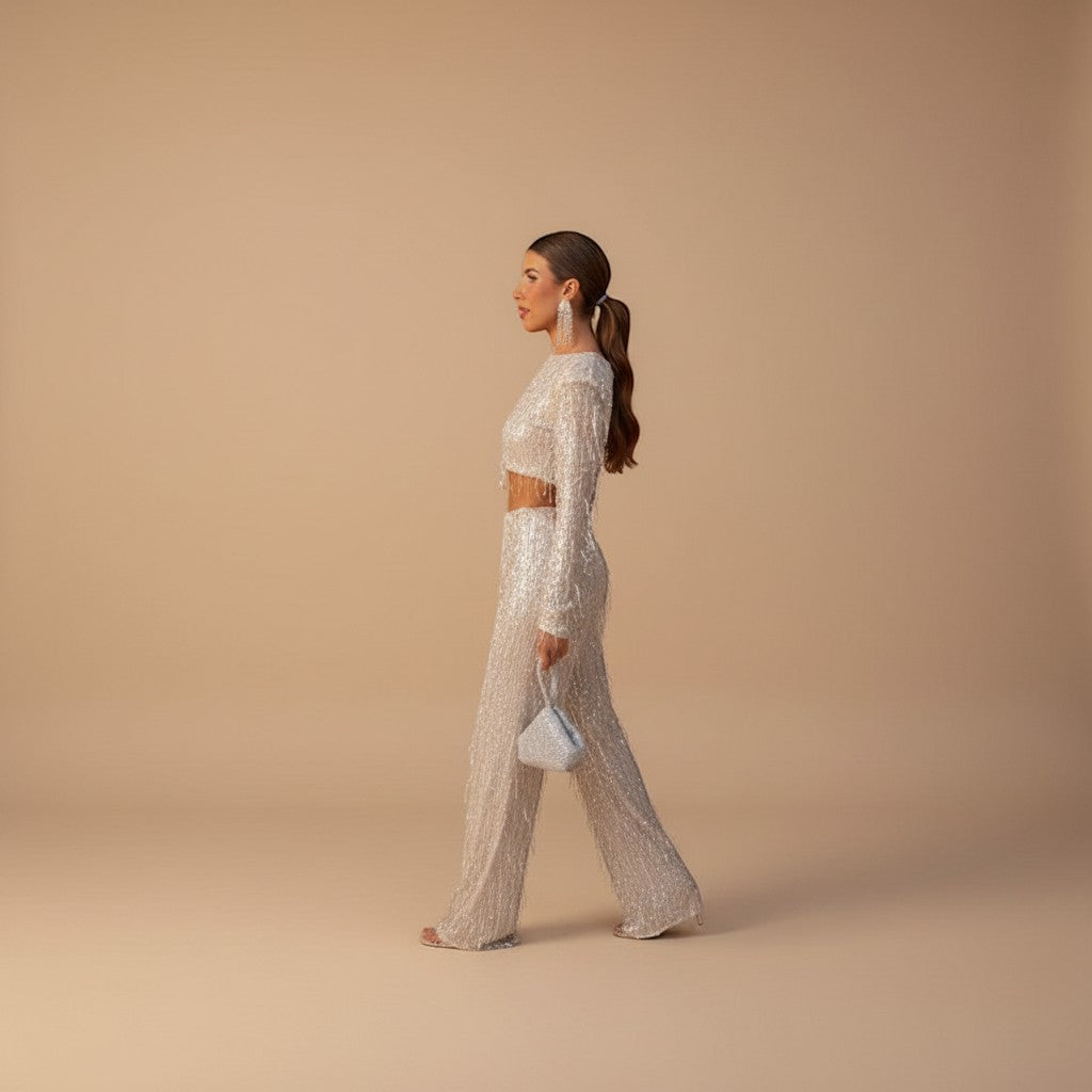 Sparkling women's sequin crop top with high-waisted wide leg pants. Two-piece glamorous party outfit.