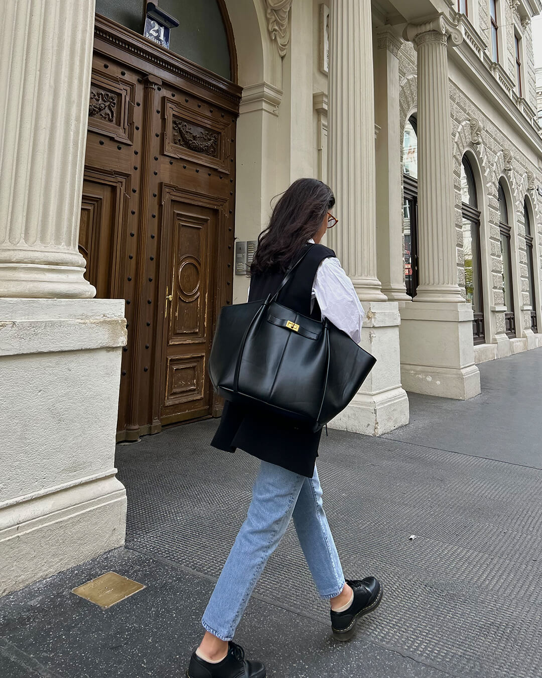 Stylish women's structured tote bag featuring elegant design and striking gold hardware. Fashionable shopper.